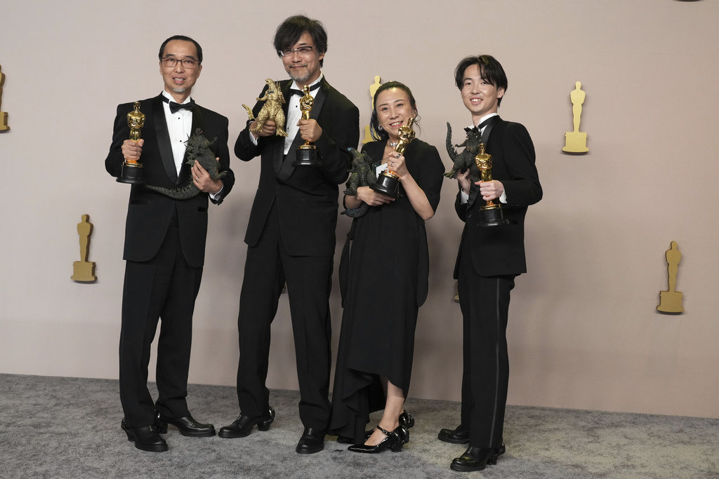 The crew of Godzilla Minus One pose with their Oscars on the red carpet.