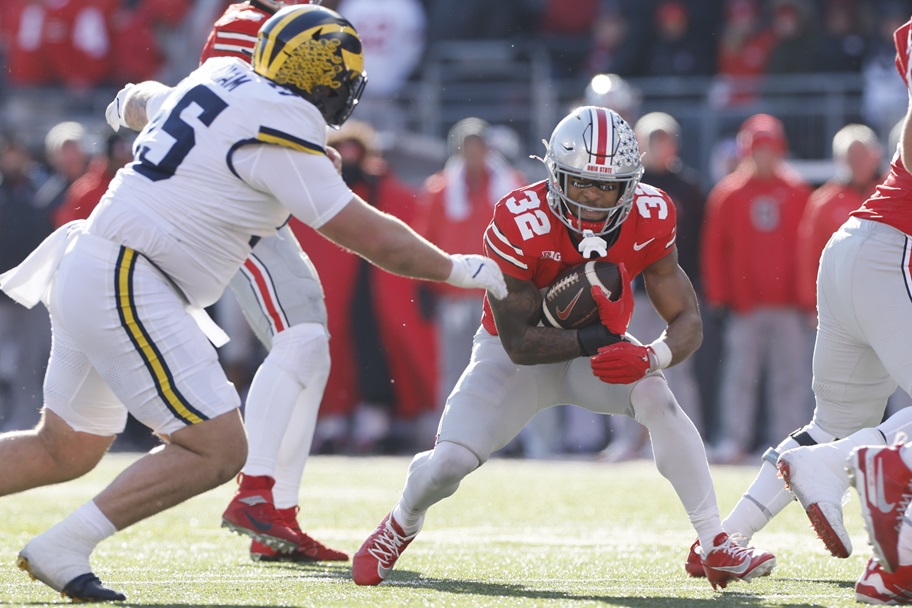 TreVeyon Henderson tries to break a tackle against Michigan.